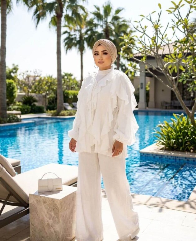 Beyaz Tasarım Takım ve uyumlu üstten oluşan şık iki parçalı kadın takımı, zarif ve modern tasarımıyla özel günler ve davetler için uygun.